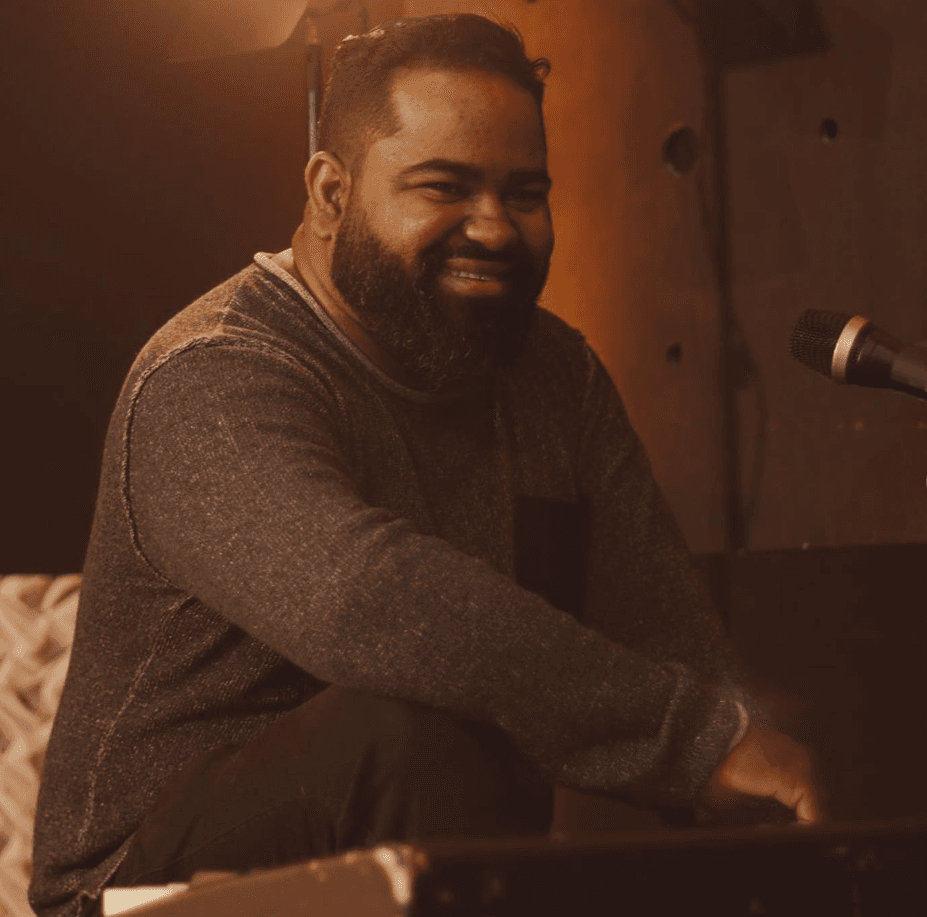 Diogo Cardoso sorrindo ao piano, em estúdio